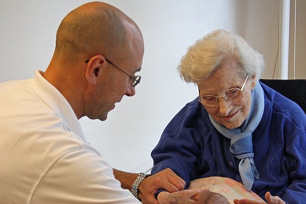 Ein Therapeut und eine Bewohnerin während der Therapie – das Bild verlinkt zur Seite der Therapiepraxis